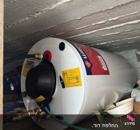 דוד שמש עם צינורות ומחברים בחדר קטן